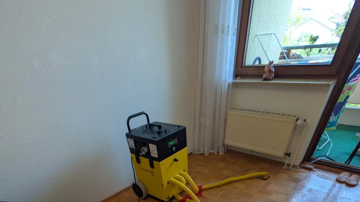 Bautrocknung im Einsatz: Trocknungsgeräte mit Schläuchen in einer Wohnung nach Wasserschaden